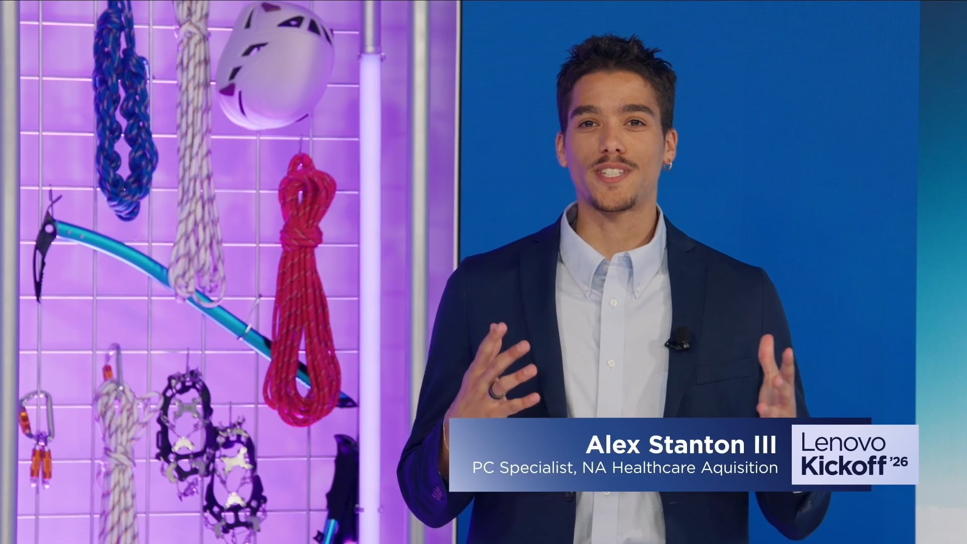 A Lenovo Kickoff '26 broadcast still of a presenter delivering remarks on the TSEC Studios set, with a lower-third graphic identifying them as a Lenovo team member.